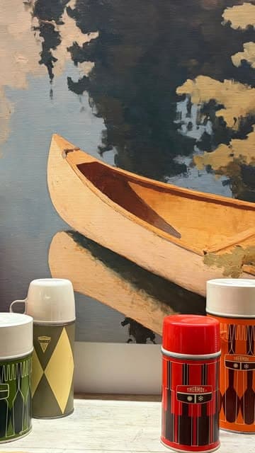 A painted canoe-on-water canvas behind a row of vintage thermoses